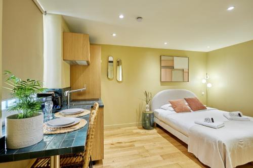 une chambre avec un lit, une table et un lavabo dans l'établissement Residence centre de Paris by Studio prestige, à Paris