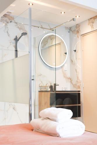 a bathroom with a mirror and a pile of towels at Hotel La Casa in Valkenburg