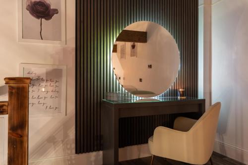 a mirror sitting on top of a table with a chair at Bradford Luxury Central Apartment with Jacuzzi in Bradford