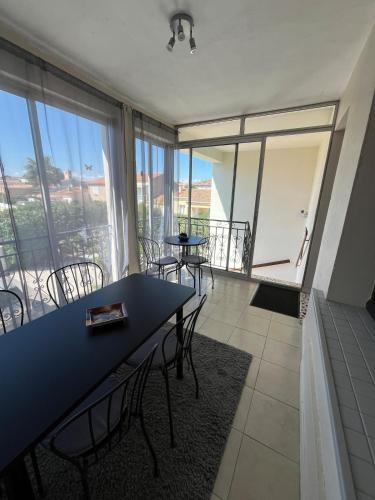 une salle à manger avec des tables et des chaises ainsi qu'une grande fenêtre dans l'établissement Appartement 4 personnes avec extérieur, à Montblanc