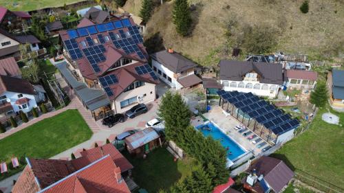 an aerial view of a house with a pool with solar panels at Pensiunea El Monte SPA in Rucăr