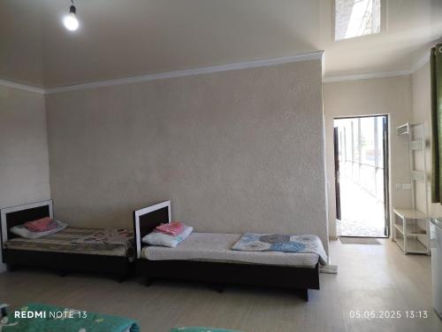 two twin beds in a room with a window at Kut Ordo in Bosteri