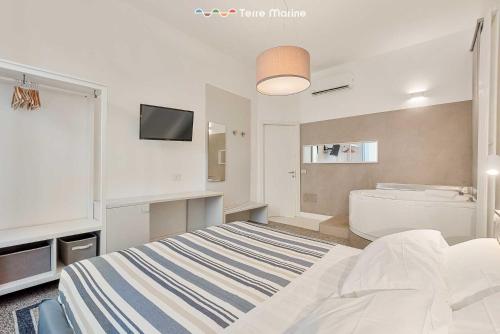 a bedroom with a bed and a tub and a television at Fedora, Terre Marine in La Spezia