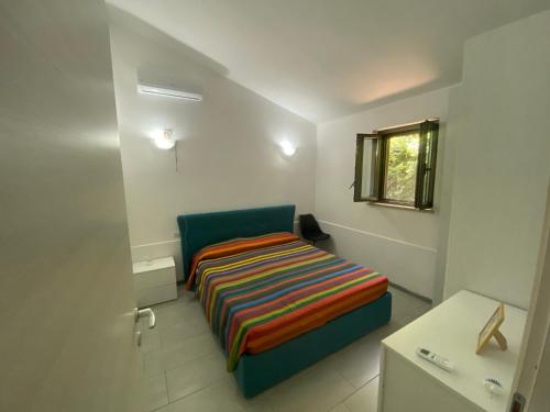 ein kleines Zimmer mit einem Bett und einem Fenster in der Unterkunft Villa VAdel Zambrone Marina in Zambrone