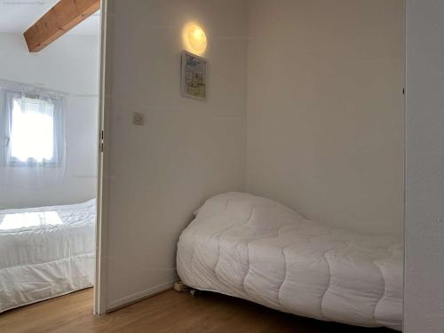 une chambre avec un lit et un miroir dans une pièce dans l'établissement NP020-037 Pavillon 3 pièces mezzanine Narbonne Plage, à Narbonne-Plage