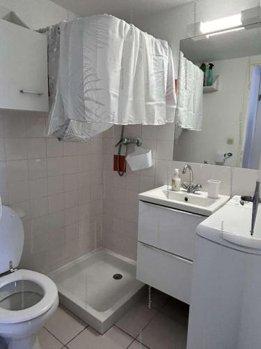une salle de bain blanche avec des toilettes et un lavabo dans l'établissement NP020-037 Pavillon 3 pièces mezzanine Narbonne Plage, à Narbonne-Plage