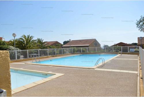 une grande piscine entourée d'une clôture. dans l'établissement NP020-037 Pavillon 3 pièces mezzanine Narbonne Plage, à Narbonne-Plage