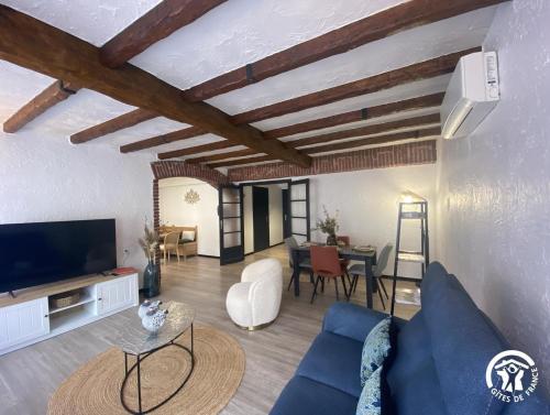 a living room with a blue couch and a table at Aqui sem be in Amélie-les-Bains-Palalda