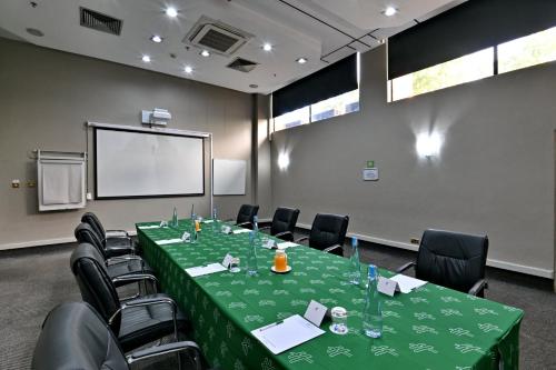 a conference room with a green table and chairs at Holiday Inn - Harare by IHG in Harare