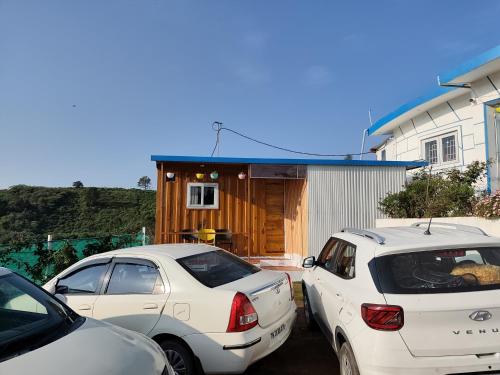 two cars parked in a parking lot in front of a house at DIAMOND HILL VIEW in Ketti