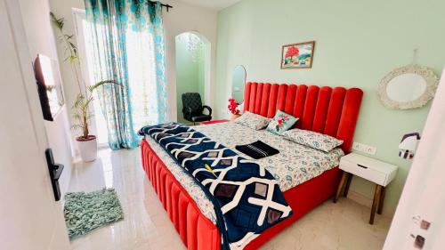a bed with a red headboard in a bedroom at Dhyani Residence in Nakraunda