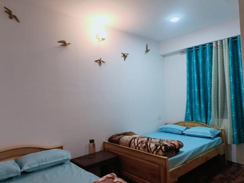 two beds in a room with blue lighting at Green heaven homestay in Kalimpong