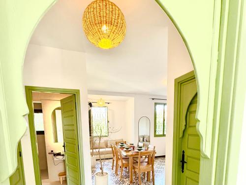 an arched doorway leads into a dining room with a table at Appartement chic et beldi à 10 minutes du centre in Essaouira