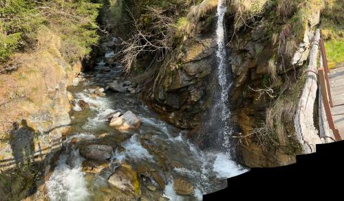 a waterfall on the side of a rocky cliff at Rustico Cascina Val Malvaglia in Malvaglia