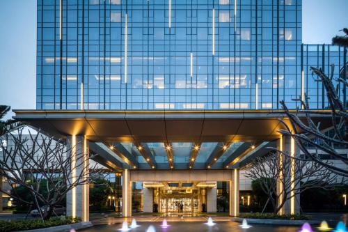 a large glass building with lights in front of it at Pullman Zhuhai in Zhuhai