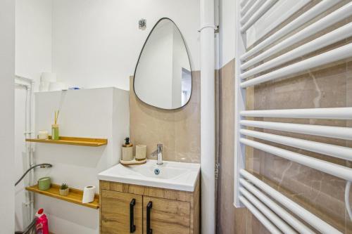 une salle de bain avec un lavabo et un miroir dans l'établissement Cozy apartment in Aubervilliers, à Aubervilliers