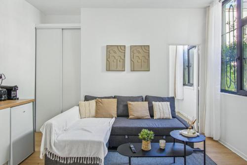 un salon avec un canapé et une table dans l'établissement Cozy apartment in Aubervilliers, à Aubervilliers