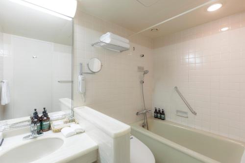 a bathroom with a sink and a toilet and a tub at ANA Crowne Plaza Kanazawa by IHG in Kanazawa
