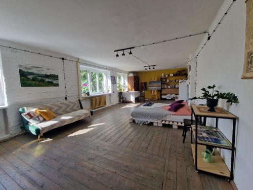 a living room with a bed and a couch at Mākslas studija Koknesē in Koknese