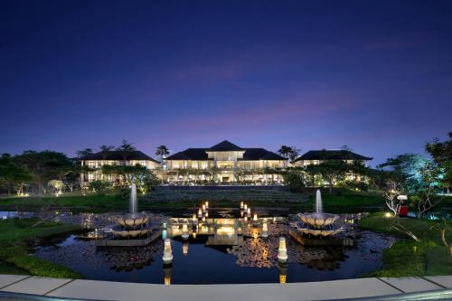 a resort with a pond in front of it at night at Rumah Luwih Bali in Keramas