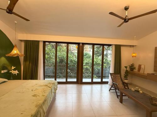 a bedroom with a large bed and a large window at Casa Susegado in Taleigao