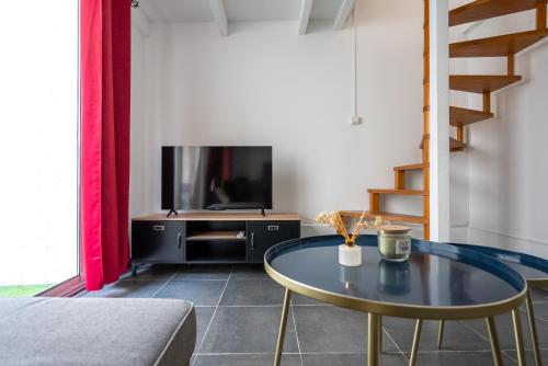 un salon avec une table et une télévision dans l'établissement Le Botinelly, à Marseille