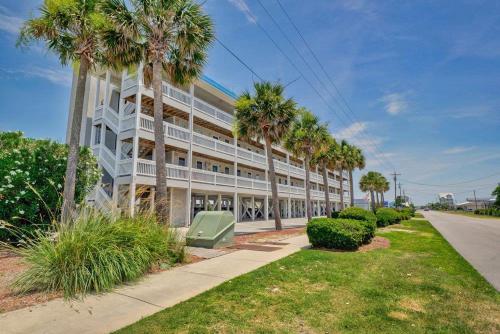 a large white building with palm trees in front of it at Oceanview Condo - Sea Coast Suites 18 in Surf City, NC in Surf City