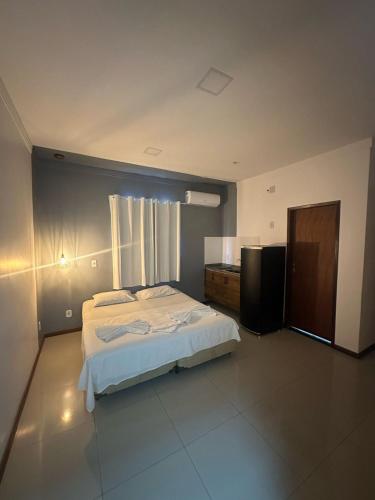 a large bedroom with a bed and a window at Pousada Aroeira in Arraial do Cabo
