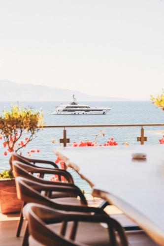 a cruise ship in the water with chairs at Hotel Apollon Sarande in Sarandë