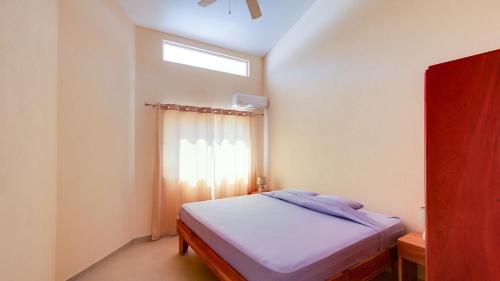 a small bedroom with a bed with a window at Villas Roma Del Mar in Playa Naranjo