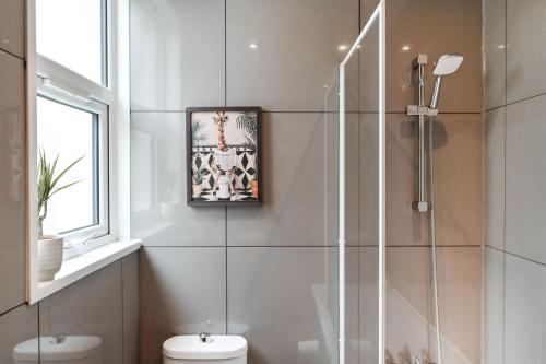 a bathroom with a shower and a toilet and a picture at South Croydon, garden maisonette, free parking, Gatwick accessible in Purley