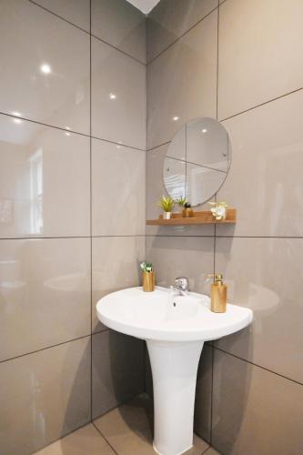 a bathroom with a white sink and a mirror at South Croydon, garden maisonette, free parking, Gatwick accessible in Purley