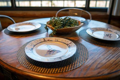 a wooden table with plates and a bowl on it at Lake Lucerne 9 -Nauti or Nice in Eureka Springs