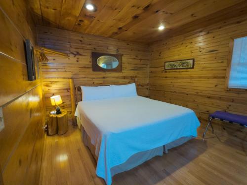 Un dormitorio con una cama en una cabaña de madera. en Wild Plum Cabin No. 2, en Eureka Springs