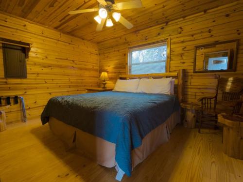 a bedroom with a bed in a log cabin at Wild Plum Cabin No. 3 in Eureka Springs