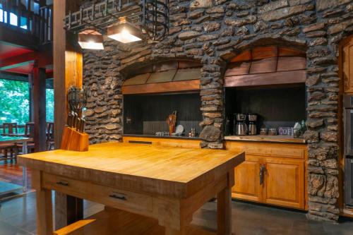cocina con encimera de madera y pared de piedra en The Ozark Deck House, en Eureka Springs