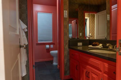 Baño rojo con lavabo y aseo en The Ozark Deck House, en Eureka Springs
