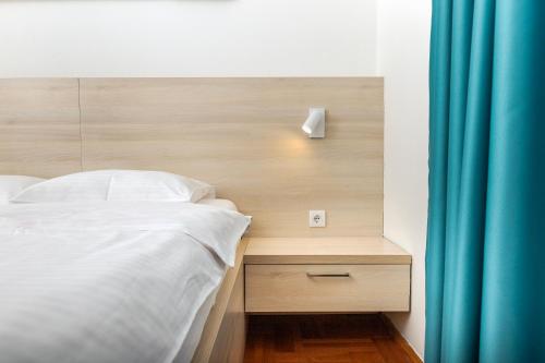 a bedroom with a bed and a blue curtain at Apartments Dončić in Kotor