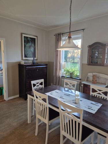 a dining room with a table and chairs at Windalens på Österlen in Tomelilla