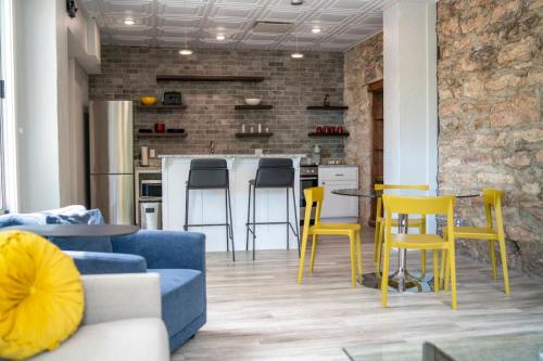 a living room with a blue couch and yellow chairs at Entire Building at 151 Spring in Eureka Springs