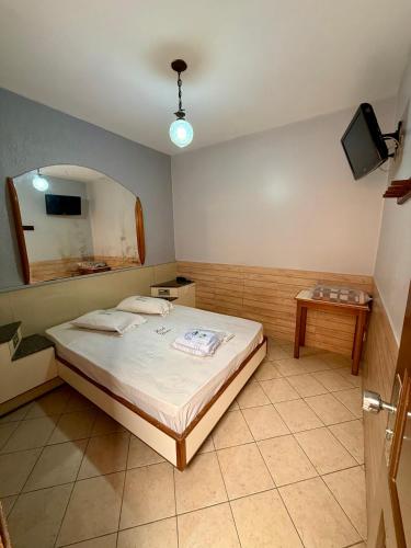 a bedroom with a large bed and a mirror at Hotel Glória in Niterói