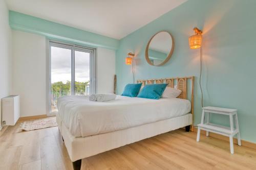 ein Schlafzimmer mit einem großen Bett und einem Spiegel in der Unterkunft Vue sur mer La Baule Hydra in La Baule