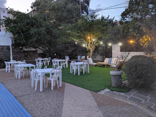 a group of white tables and chairs on a lawn at Astoria Galilee Hotel in Tiberias