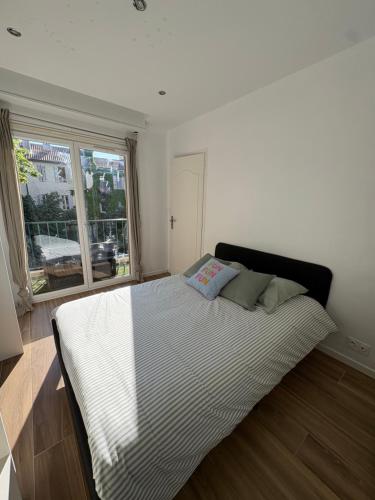 un grand lit dans une chambre avec une fenêtre dans l'établissement Appartement 2 chambres proche plage, à Marseille