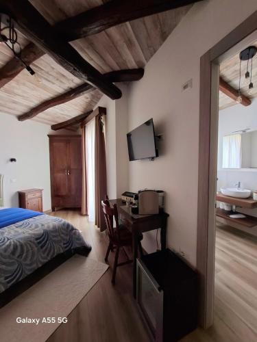 a bedroom with a bed and a desk with a television at Biginau ' e giosso in Ilbono