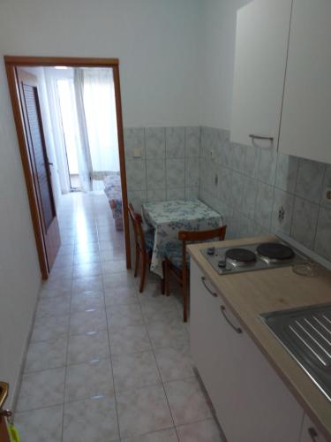 a kitchen with a stove and a table with a table at MIRKO DIVING CENTER in Rab