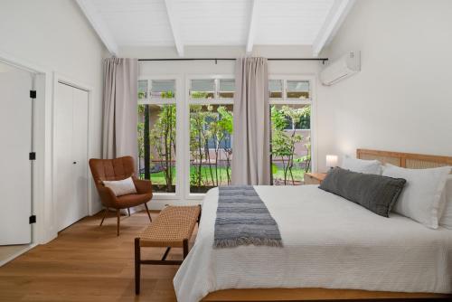 a bedroom with a bed and a chair and a window at F-71 Queens Bath Point in Princeville