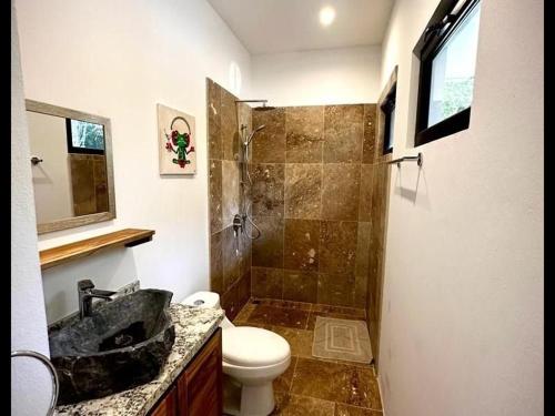 a bathroom with a shower and a toilet and a sink at Villas Roma Del Mar in Playa Naranjo