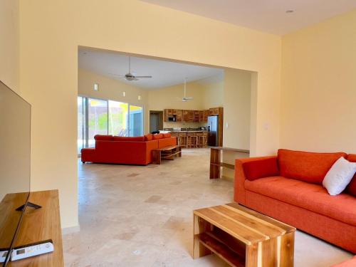 a living room with a red couch and a table at Villas Roma Del Mar in Playa Naranjo