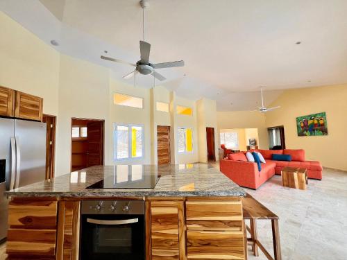 a kitchen and living room with a ceiling fan at Villas Roma Del Mar in Playa Naranjo